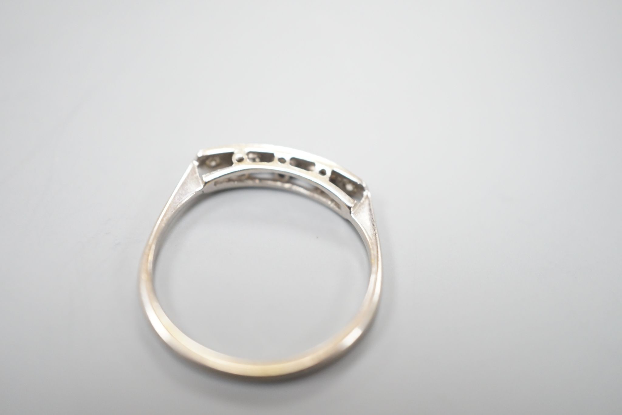 An 18ct and plat, graduated five stone diamond set half hoop ring, size N, gross weight 1.8 grams.